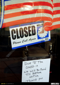 COVID-19 lockdowns - glass door with USA flag and a sign that says "Closed, Due to COVID-19 We will be closed til further notice" 